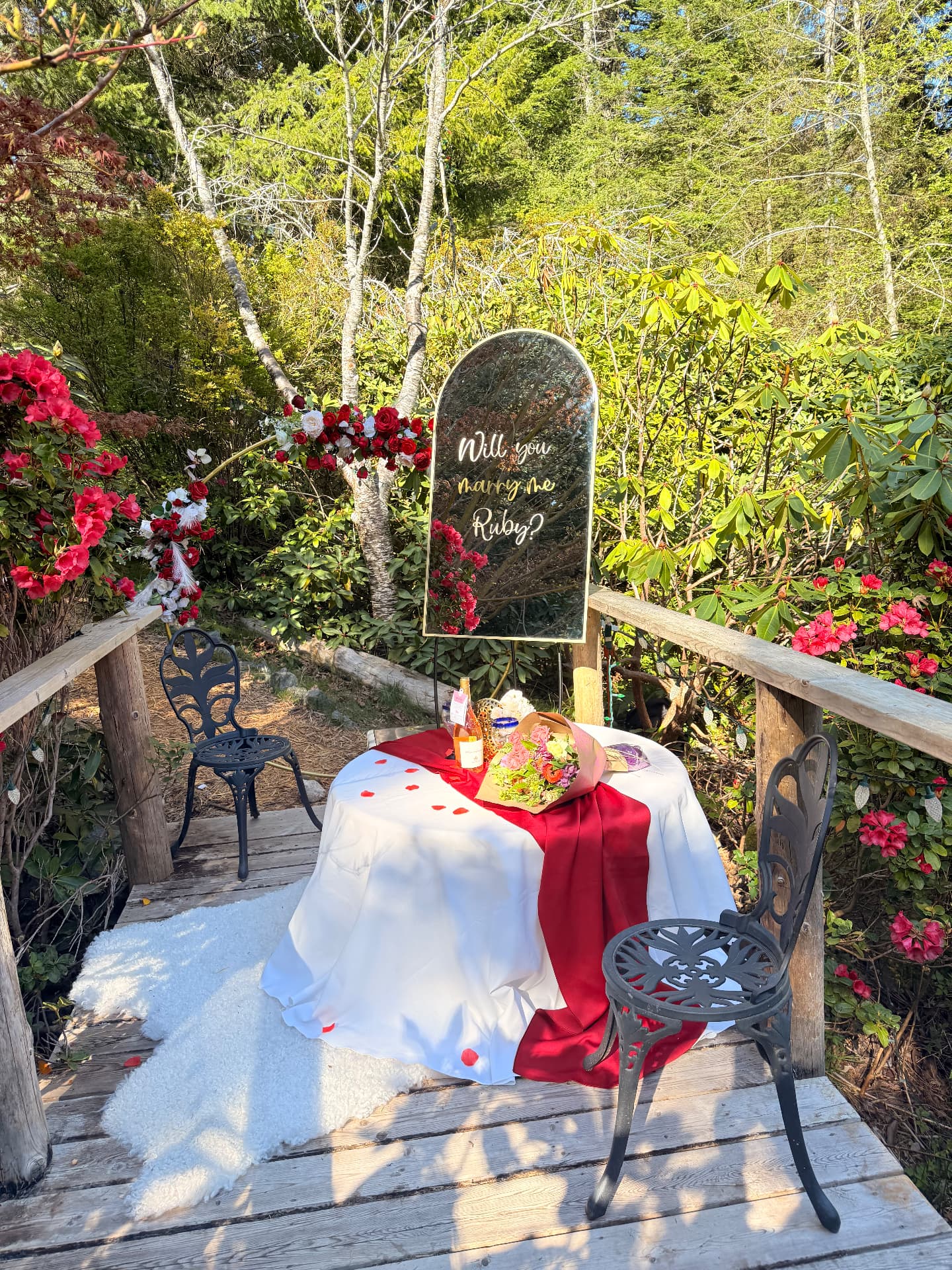 Romantic outdoor proposal with mirror sign, red roses and styled table