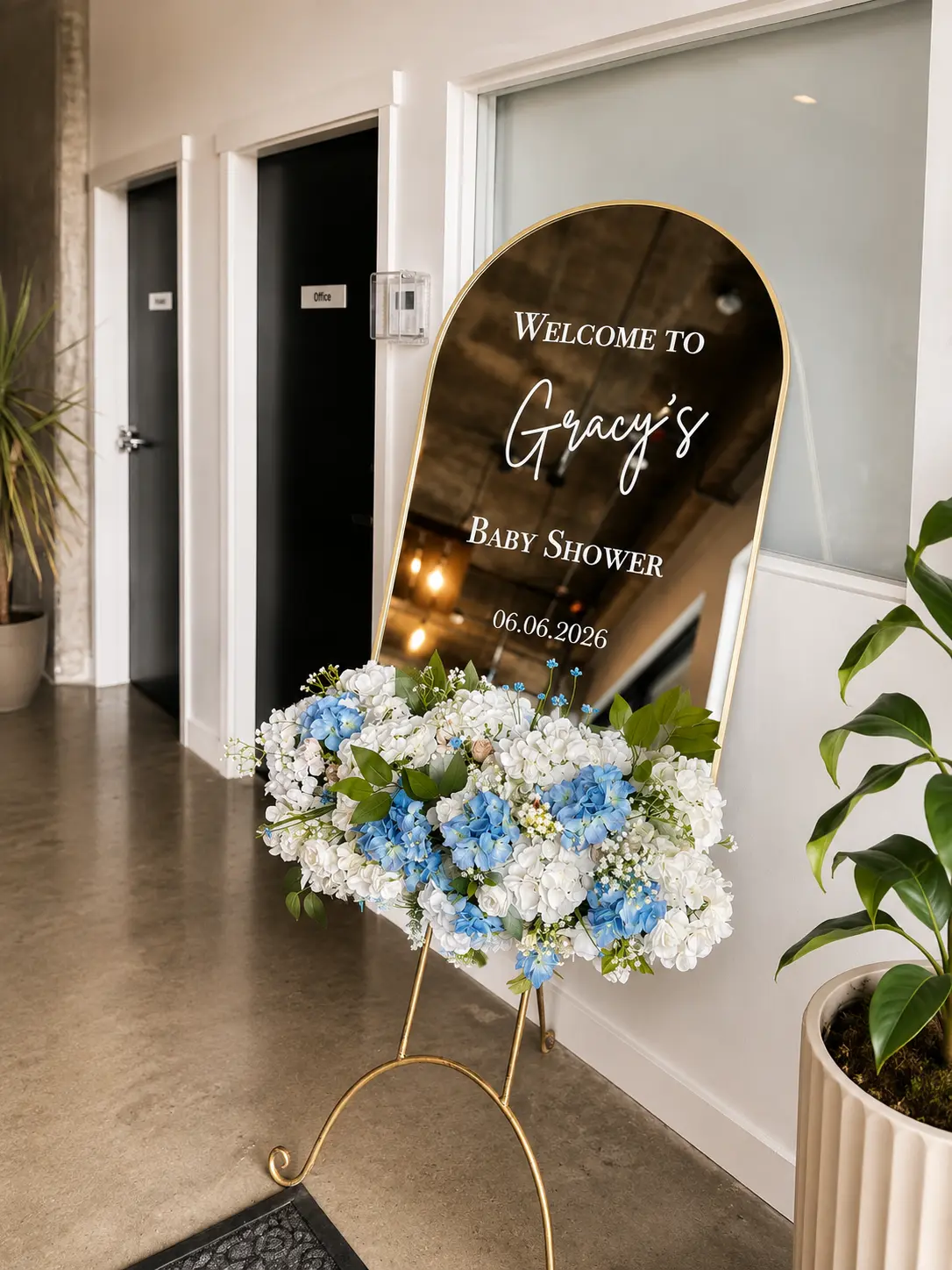 Gold mirror welcome sign with blue and white floral arrangement